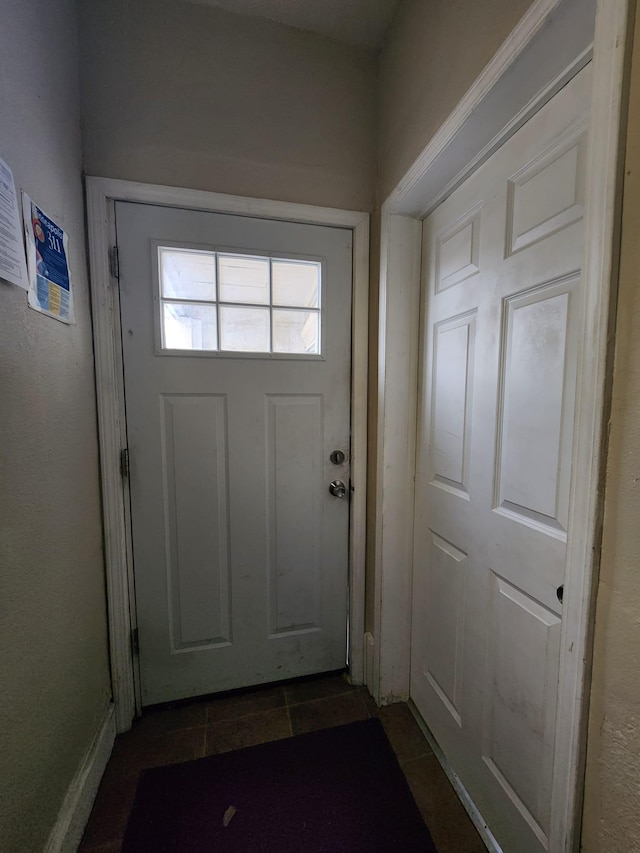 doorway featuring dark tile patterned flooring