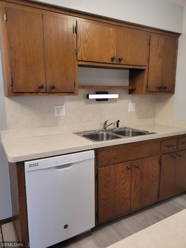 kitchen featuring decorative backsplash, dishwasher, light hardwood / wood-style floors, and sink