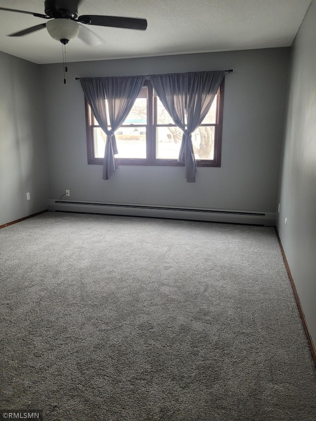 carpeted empty room featuring ceiling fan, plenty of natural light, a textured ceiling, and a baseboard heating unit