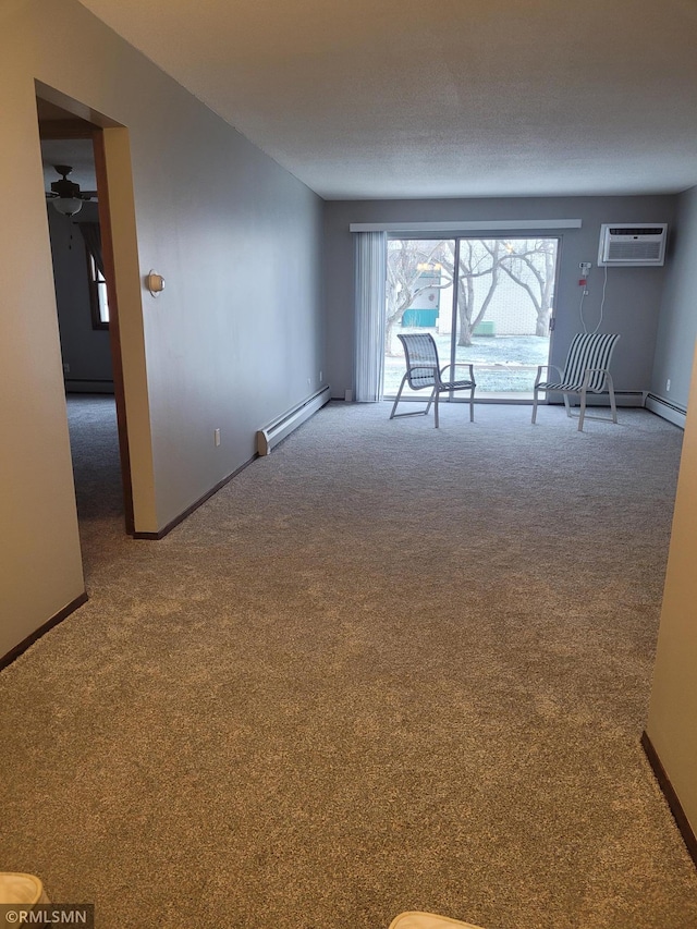 carpeted spare room with ceiling fan, baseboard heating, and a wall unit AC