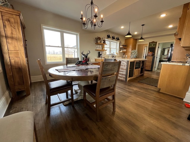 dining space featuring dark hardwood / wood-style flooring, an inviting chandelier, and sink