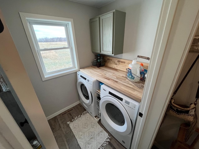 laundry room featuring separate washer and dryer, dark hardwood / wood-style flooring, and cabinets