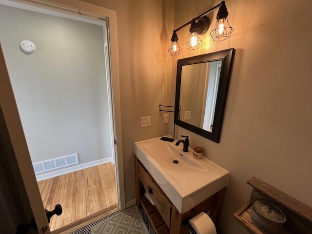 bathroom with hardwood / wood-style floors and vanity