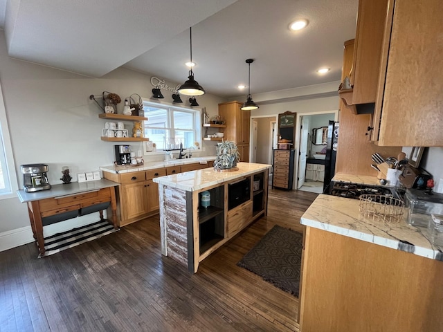 kitchen with dark hardwood / wood-style flooring, light stone counters, sink, black appliances, and pendant lighting