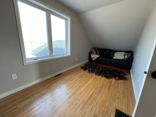 additional living space with light hardwood / wood-style floors and lofted ceiling