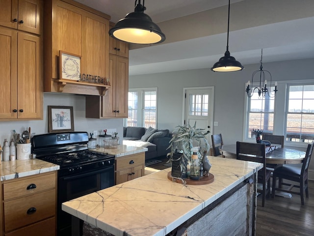 kitchen with a chandelier, black range with gas stovetop, dark wood-type flooring, and a healthy amount of sunlight