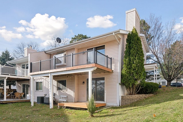 back of property with a balcony, a deck, cooling unit, and a lawn