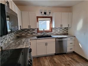 kitchen featuring backsplash, dark hardwood / wood-style flooring, stainless steel appliances, sink, and white cabinetry