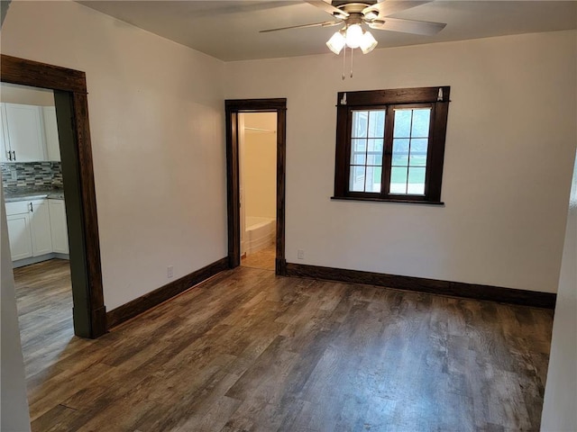 spare room with dark hardwood / wood-style floors and ceiling fan