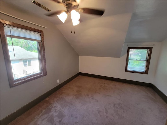 additional living space with ceiling fan, light colored carpet, and vaulted ceiling