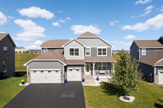 view of front of home featuring a garage, a front lawn, and covered porch