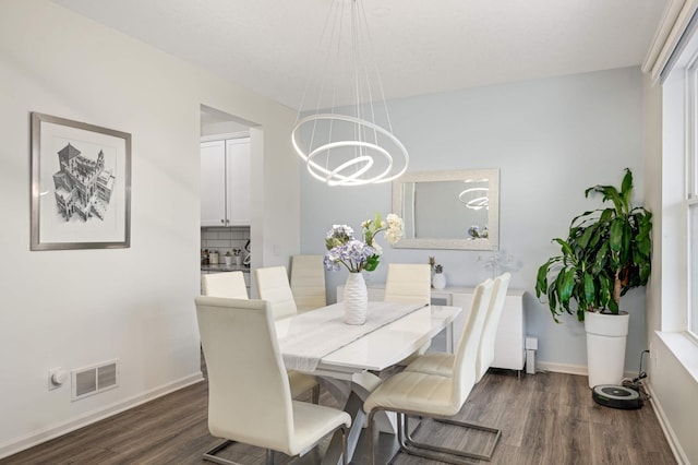 dining space featuring an inviting chandelier and dark wood-type flooring