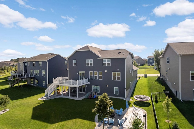 rear view of house featuring a patio area, a yard, and a deck