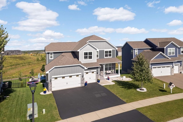 craftsman inspired home with a garage and a front yard