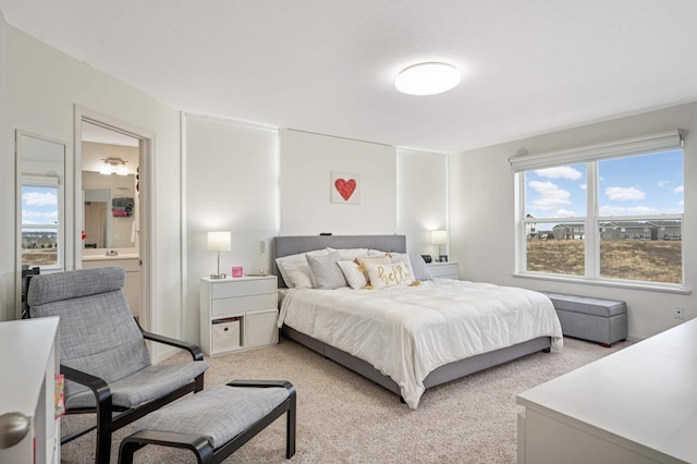 bedroom with light carpet and ensuite bath