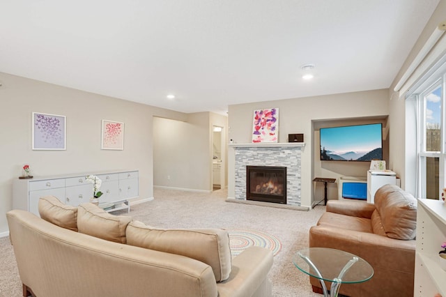 living room with a stone fireplace and light carpet