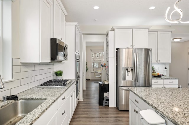 kitchen with white cabinetry, appliances with stainless steel finishes, sink, and decorative backsplash