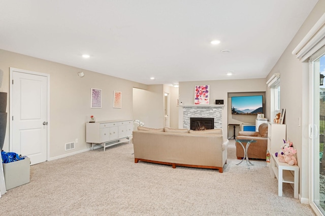 carpeted living room featuring a tiled fireplace