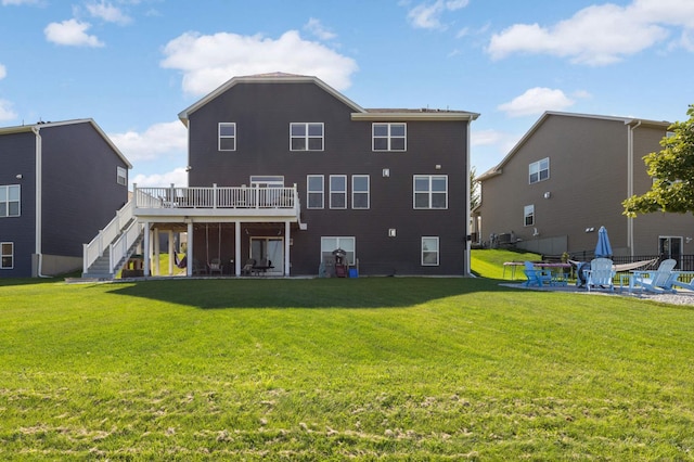 back of house featuring a lawn, a patio, and a deck