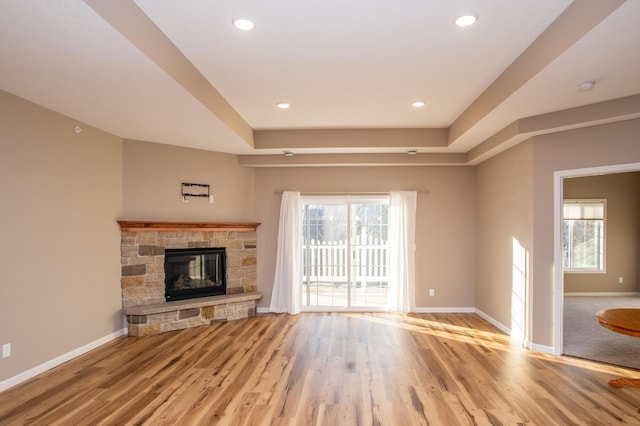 unfurnished living room featuring a fireplace, light hardwood / wood-style flooring, and a healthy amount of sunlight