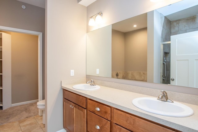 bathroom featuring tile patterned flooring, vanity, toilet, and a shower with shower door