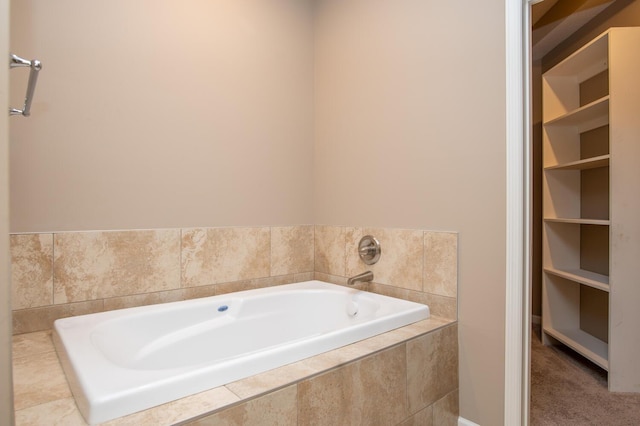 bathroom with built in shelves and a relaxing tiled tub