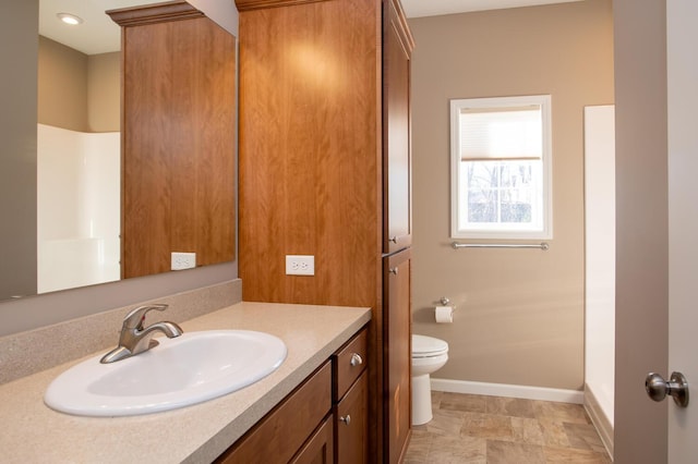 bathroom with vanity, toilet, and baseboards