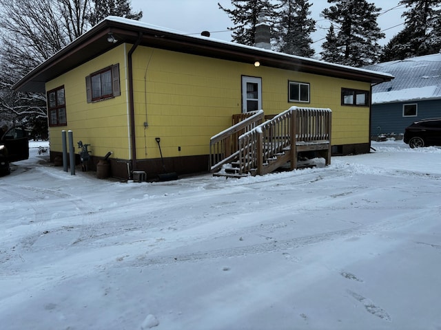 view of snow covered rear of property