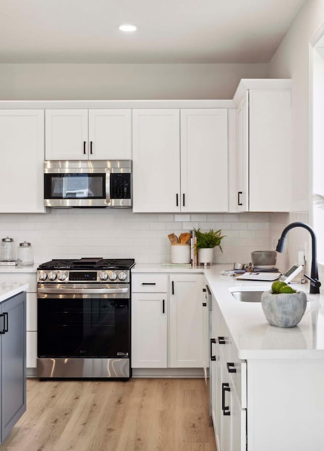 kitchen featuring white cabinets, backsplash, sink, and stainless steel appliances