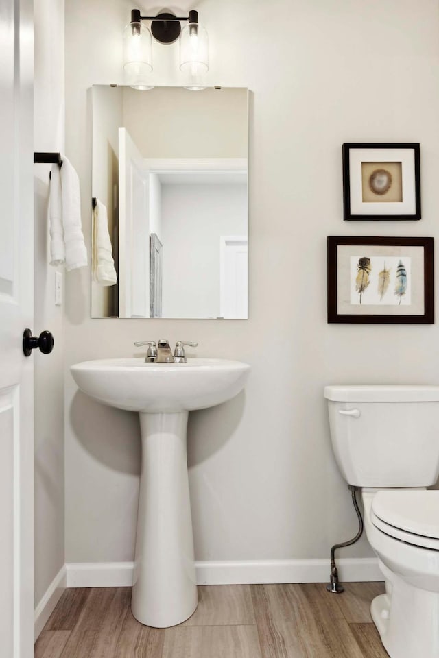 bathroom with toilet and hardwood / wood-style flooring