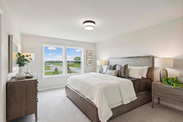 bedroom featuring a textured ceiling and light colored carpet