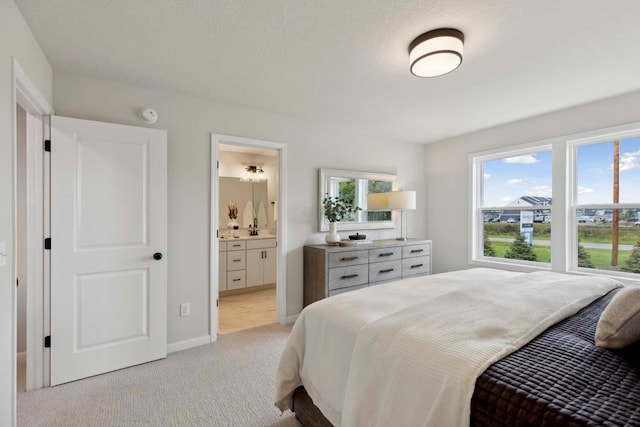 carpeted bedroom featuring a textured ceiling, connected bathroom, and multiple windows