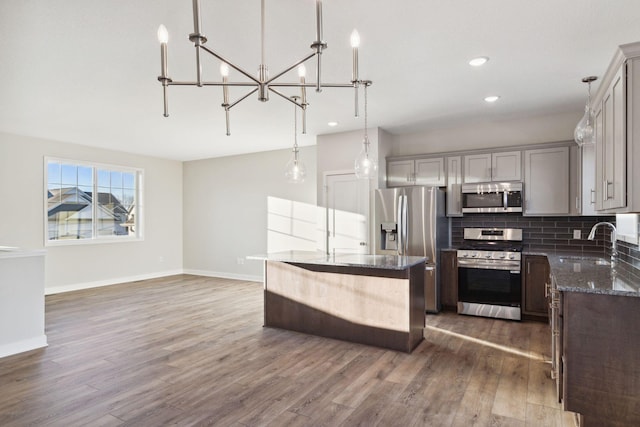 kitchen with sink, gray cabinets, stainless steel appliances, and hanging light fixtures