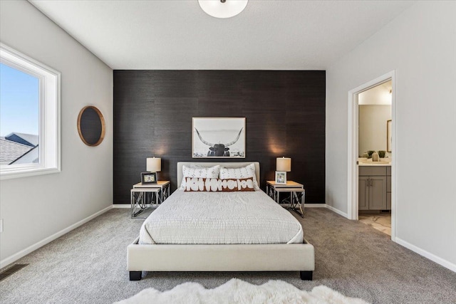 bedroom with light colored carpet and ensuite bathroom