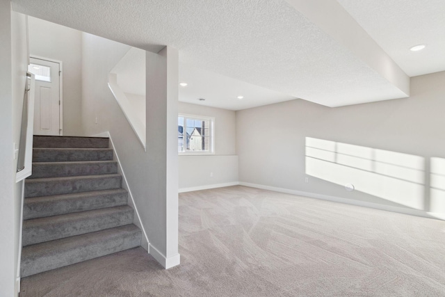 stairs featuring carpet floors and a textured ceiling