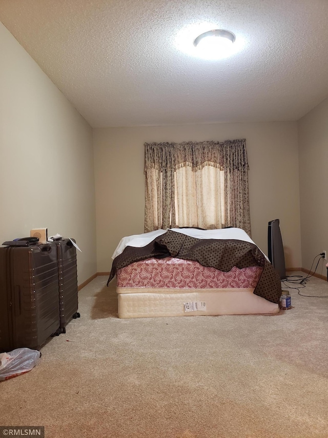 bedroom with light colored carpet and a textured ceiling