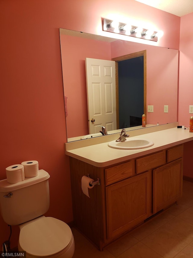 bathroom with tile patterned flooring, vanity, and toilet