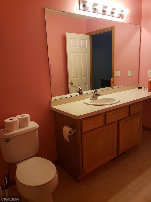 bathroom with toilet, vanity, and tile patterned floors