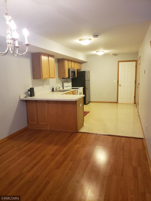 kitchen with pendant lighting, an inviting chandelier, light hardwood / wood-style flooring, appliances with stainless steel finishes, and kitchen peninsula