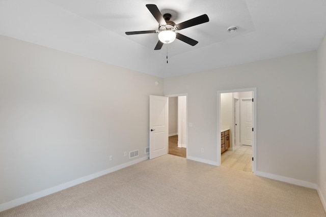 unfurnished bedroom featuring light carpet, ensuite bath, and ceiling fan