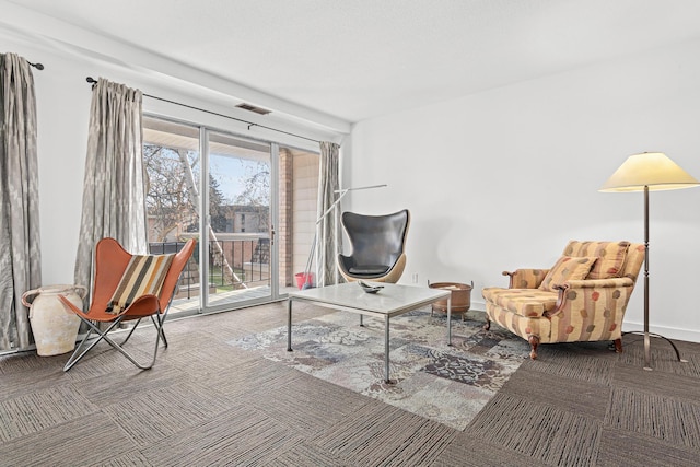 living area with baseboards, visible vents, and carpet flooring