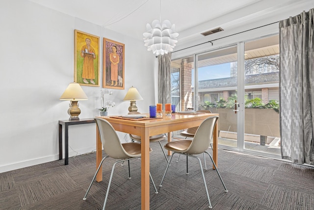 carpeted dining area featuring an inviting chandelier, visible vents, and baseboards