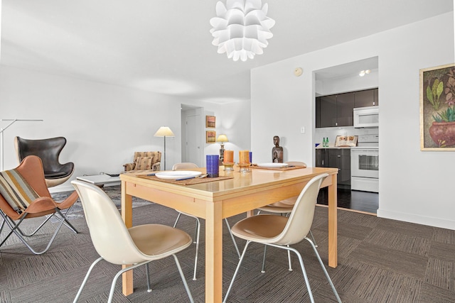 dining area featuring baseboards and a chandelier