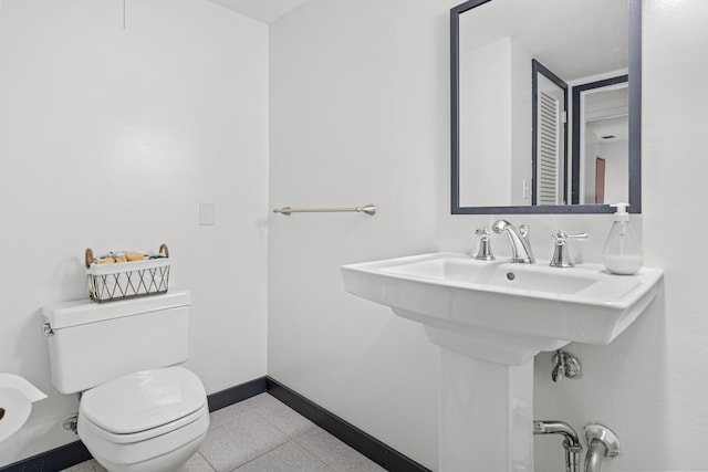 bathroom with a sink, toilet, and baseboards