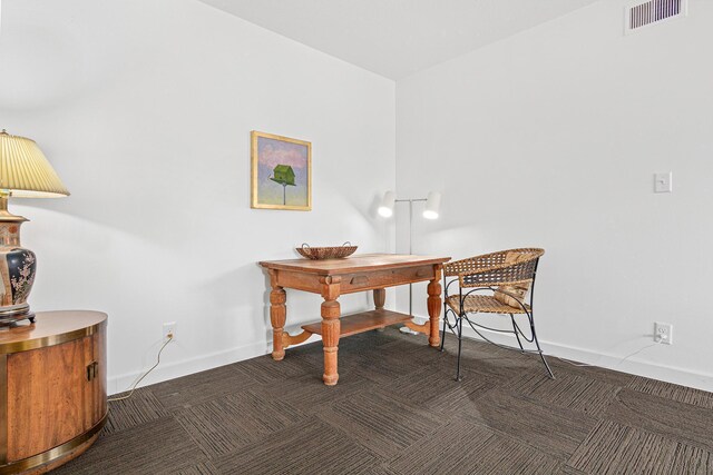 carpeted office space with visible vents and baseboards