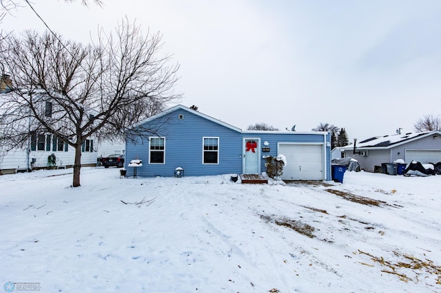 snow covered house with a garage