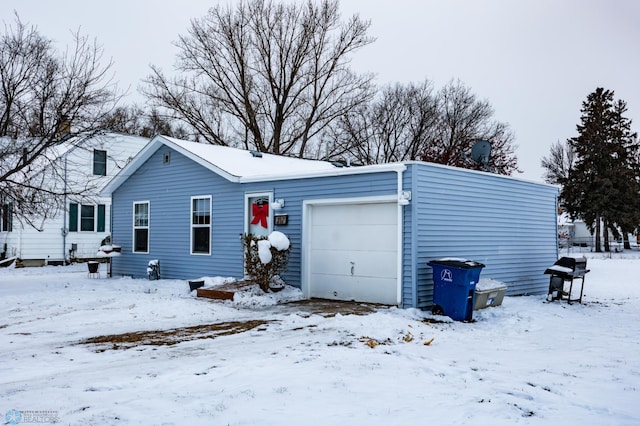 view of snow covered exterior featuring a garage