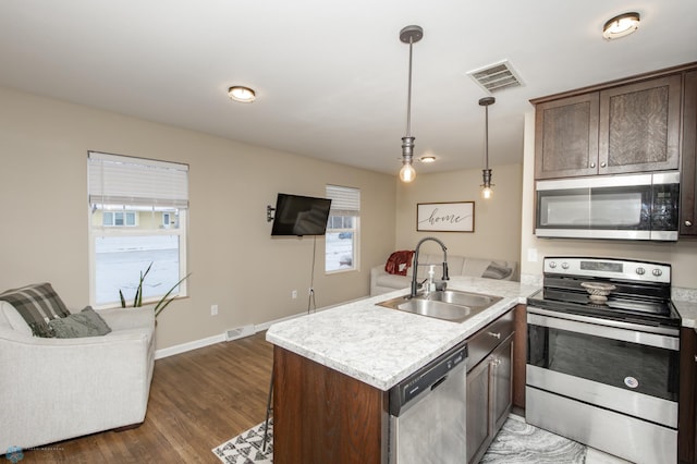 kitchen featuring sink, stainless steel appliances, dark hardwood / wood-style floors, decorative light fixtures, and dark brown cabinets