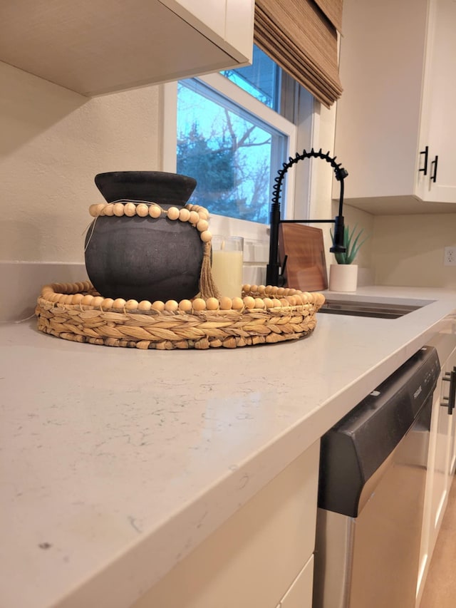 interior details featuring dishwasher and white cabinets