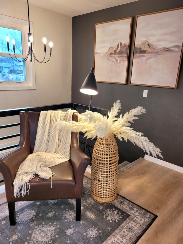 living area with wood-type flooring and a notable chandelier